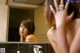 A naked woman looking at herself in the mirror.
