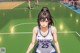 A woman in a blue and white uniform standing on a basketball court.