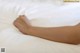 A close up of a person's arm on a bed.