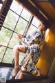 A woman in a kimono sitting on a window sill.